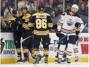 Boston Bruins center Joakim Nordstrom (20) celebrates after scoring a goal with teammates Jake DeBrusk, left, and Kevan Miller (86) as Edmonton Oilers defenseman Adam Larsson (6) skates away during the first period of an NHL hockey game Thursday, Oct. 11, 2018, in Boston.