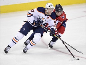 Washington Capitals center Evgeny Kuznetsov (92), of Russia, battles for the puck against Edmonton Oilers center Connor McDavid (97) during the third period of an NHL hockey game, Sunday, Nov. 12, 2017, in Washington. The Capitals won 2-1 in a shootout.