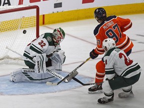 Edmonton Oilers captain Connor McDavid skates past Minnesota Wild defenceman Matt Dumba and scores on goalie Alex Stalock during second period NHL hockey game action in Edmonton on Tuesday, Oct. 30, 2018.