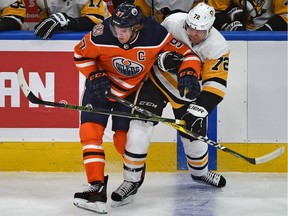 Pittsburgh Penguins Patric Hornqvist tries to hold onto Edmonton Oilers Connor McDavid during NHL action at Rogers Place in Edmonton, October 23, 2018.