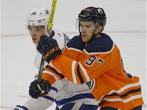 Toronto Maple Leaf Auston Matthews (left) is checked by Edmonton Oiler Connor McDavid (right) during NHL game action in Edmonton on November 30, 2017.