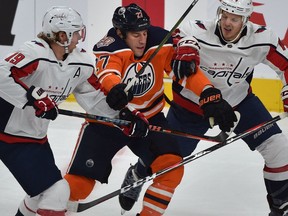 Edmonton Oilers Milan Lucic gets hemmed in by Washington Capitals' Nicklas Backstrom, left, and John Carlson during NHL action at Rogers Place on Thursday, Oct. 25, 2018.