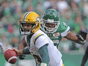 Edmonton Eskimos quarterback Mike Reilly is brought down by Saskatchewan Roughriders defensive lineman Willie Jefferson during first half CFL action in Regina on Monday, Oct. 8, 2018.