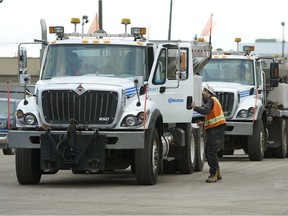 City trucks in Edmonton prepare to leave for Calgary on Tuesday evening. A work crew of 60 left Edmonton with 30 snow plows to help Calgary clear snow after a massive storm.
