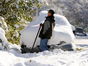 Greg Schmid shovels to get his car out at his N.W. home as Calgary will be on the clean up after a massive October snow storm crippling the city on Wednesday October 3, 2018.