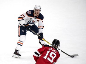 Edmonton Oilers' Connor McDavid, background and New Jersey Devils' Travis Zajac vie for the puck, during the season-opening NHL Global Series hockey match between Edmonton Oilers and New Jersey Devils at Scandinavium in Gothenburg, Sweden, Saturday, Oct. 6, 2018, (Bjorn Larsson Rosvall /TT News Agency via AP) ORG XMIT: AMB824