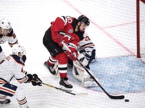 New Jersey Devils' Marcus Johansson passes Edmonton Oilers' goalie Cam Talbots, during the season-opening NHL Global Series hockey match between Edmonton Oilers and New Jersey Devils at Scandinavium in Gothenburg, Sweden, Saturday, Oct. 6, 2018,