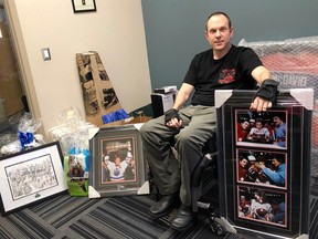Nic Good, aka 'The Good Guy,' poses surrounded by auction items from the ATCO Edmonton Sun Christmas Charity Aution on Wednesday. Cam Tait/Edmonton Sun