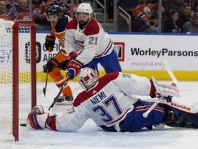 An Edmonton Oilers' shot bounces off the board and behind the Montreal Canadiens' Antti Niemi for the Oilers' first goal during first period NHL action at Rogers Place, Tuesday, Nov. 13, 2018.