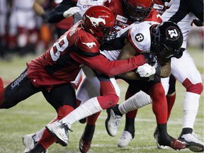 The Calgary Stampeders' Wynton McManis (48) and Tunde Adeleke (27) tackle the Ottawa Redblacks' R.J. Harris (84) during second half Grey Cup action at Commonwealth Stadium, in Edmonton Sunday November 25, 2018. Calgary won 27 to 16. Photo by David Bloom