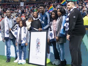 Vancouver Whitecaps midfielder Alphonso Davies, centre, poses for photographs with family members after being honoured before playing his final match as a member of the MLS soccer team, in Vancouver on Sunday, Oct. 28, 2018.