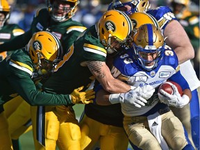 A team of Edmonton Eskimos wrap up Winnipeg Blue Bombers running back Andrew Harris (33) during CFL action in the last game of the season at Commonwealth Stadium in Edmonton, November 3, 2018. Ed Kaiser/Postmedia