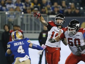 Calgary Stampeders quarterback Bo Levi Mitchell (19) throws with pressure from Winnipeg Blue Bombers' Adam Bighill (4) during the first half of CFL action in Winnipeg, Friday, Oct. 26, 2018.