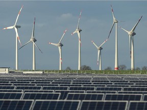 Wind turbines overlook solar panels.