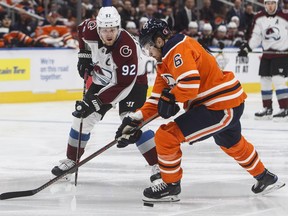 Colorado Avalanche' Gabriel Landeskog (92) and Edmonton Oilers' Adam Larsson (6) battle for the puck during first period NHL action at Rogers Place on Sunday, Nov. 11, 2018.