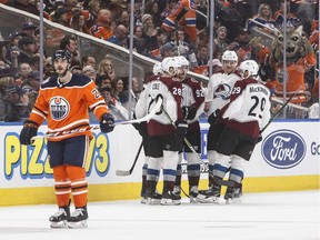 Colorado Avalanche players celebrate a goal as Edmonton Oilers' Tobias Rieder skates past during second period NHL action in Edmonton,  on Sunday, Nov. 11, 2018.