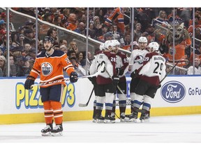 Colorado Avalanche players celebrate a goal as Edmonton Oilers' Tobias Rieder (22) skates past during second period NHL action in Edmonton, Alta., on Sunday November 11, 2018.