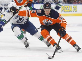 Vancouver Canucks' Derrick Pouliot chases Edmonton Oilers' Jesse Puljujarvi during a pre-season game at Rogers Place, Sept. 25, 2018.