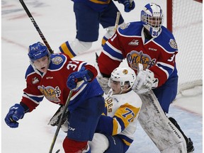 Edmonton Oil Kings Conner McDonald (left) received an interference penalty while checking Saskatoon Blades Kirby Dach in front of Oil Kings goalie Dylan Myskiw (right) during second period WHL hockey action in Edmonton on Wednesday October 3, 2018.