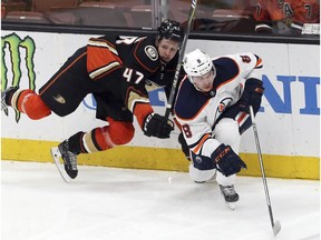 Anaheim Ducks defenseman Hampus Lindholm (47) and Edmonton Oilers right winger Ty Rattie (8) tangle in the second period of an NHL hockey game in Anaheim, Calif., Sunday, Feb. 25, 2018.