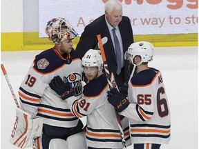 Edmonton Oilers goaltender Mikko Koskinen (19), from Finland, celebrates with left wing Drake Caggiula (91) and center Cooper Marody (65) in front of head coach Ken Hitchcock after beating the San Jose Sharks in overtime of an NHL hockey game in San Jose, Calif., Tuesday, Nov. 20, 2018.