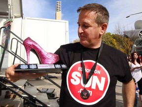 John Caputo is constantly involved in events helping the community. Here, he's shown participating inthe Walk a Mile in Her Shoes event in 2014, posing with his trophy for raising the largest amount in donations.