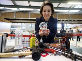 Canadian Air Transport Security Authority (CATSA) spokeswoman Christine Langlois holds a snow globe as she looks at items that were surrendered by passengers before going through security screening at the Edmonton International Airport.