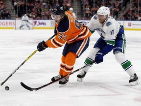 The Edmonton Oilers' Connor McDavid (97) battles the Vancouver Canucks' Josh Leivo (17) during first period NHL action at Rogers Place, in Edmonton Thursday Dec. 27, 2018.