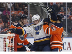 St. Louis Blues' David Perron (57) is roughed up by Edmonton Oilers' Ryan Nugent-Hopkins (93) and Caleb Jones (82) during first period NHL action in Edmonton, Alta., on Tuesday December 18, 2018.
