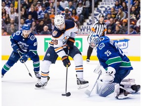 Edmonton Oilers' Alex Chiasson (39) tries to redirect the puck in front of Vancouver Canucks goalie Jacob Markstrom, of Sweden, while being watched by Tyler Motte, back left, during third period NHL hockey action in Vancouver on Sunday, Dec. 16, 2018.
