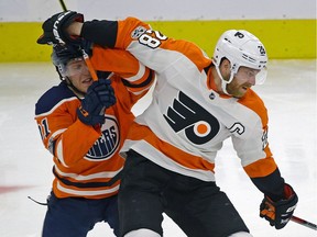 Philadelphia Flyer Claude Giroux (right) is checked by Edmonton Oiler Drake Caggiula (left) during second period NHL game action in Edmonton on Wednesday December 6, 2017.