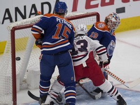 The puck gets past Edmonton Oilers goalie Mikko Koskinen (19) but not in the net as Alex Petrovic (15) and Winnipeg Jets Brandon Tanev (13) watch during first period NHL action on Monday, Dec. 31, 2018 in Edmonton.