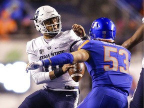 Utah State quarterback Jordan Love (10) tries to avoid the pressure brought by Boise State linebacker Sam Whitney (53) in the second of an NCAA college football game, Saturday, Nov. 24, 2018, in Boise, Idaho. Boise State won 33-24.