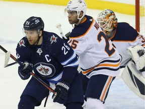 Winnipeg Jets forward Blake Wheeler (left) battles for position in front of Edmonton Oilers goaltender Cam Talbot with defenceman Darnell Nurse in Winnipeg on Thurs., Dec. 13, 2018.