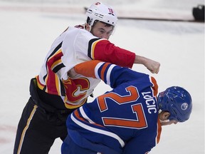 Edmonton Oilers Milan Lucic (27) Calgary Flames Anthony Peluso (16) exchange blows during first period NHL action on Sunday, Dec. 9, 2018, in Edmonton.