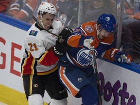 Edmonton Oilers Oscar Klefbom (77) and Calgary Flames Garnet Hathaway (21) battle for the puck during second period NHL action on Sunday, Dec. 9, 2018, in Edmonton.