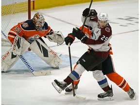 Colorado Avalanche center Nathan MacKinnon (#29) is checked by Edmonton Oiler defenceman Darnell Nurse in front of Oilers goalie Cam Talbot (left) during first period NHL hockey game action in Edmonton on Sunday November 11, 2018.