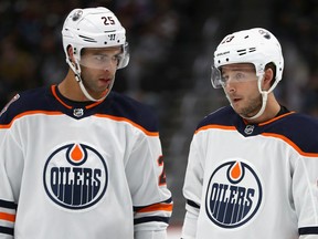 Darnell Nurse, left, and Ryan Spooner of the Edmonton Oilers confer while playing the Colorado Avalanche at the Pepsi Center on Dec. 11, 2018 in Denver, CO.