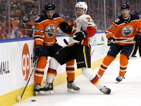 The Edmonton Oilers' Connor McDavid (97) battles the Calgary Flames Garnet Hathaway (21) during first period NHL action at Rogers Place, in Edmonton Saturday Jan. 19, 2019.
