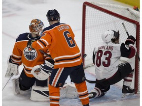 Edmonton Oilers goalie Cam Talbot (33) and Adam Larsson (6) watch as Arizona Coyotes  Conor Garland deflects the puck into the net with his head during second period NHL action on Saturday, Jan. 12, 2019  in Edmonton.