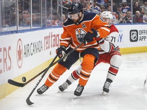 Carolina Hurricanes' Lucas Wallmark (71) and Edmonton Oilers' Adam Larsson (6) battle for the puck during first period NHL action in Edmonton, Alta., on Sunday January 20, 2019.