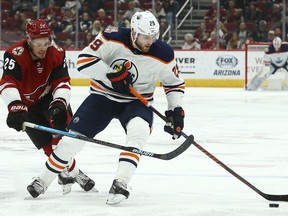 Edmonton Oilers center Leon Draisaitl (29) tries to keep the puck away from Arizona Coyotes center Nick Cousins (25) during the first period of an NHL hockey game Wednesday, Jan. 2, 2019, in Glendale, Ariz.