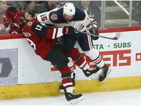 Edmonton Oilers defenseman Alexander Petrovic (15) checks Arizona Coyotes center Vinnie Hinostroza (13) during the third period of an NHL hockey game on Jan. 2, 2019, in Glendale, Ariz.