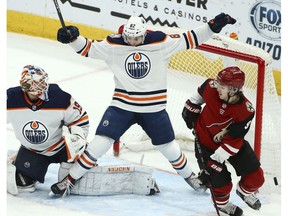 Edmonton Oilers defenseman Caleb Jones (82) helps goaltender Mikko Koskinen (19) protect the goal as Arizona Coyotes center Clayton Keller (9) looks for the puck during the third period of an NHL hockey game Wednesday, Jan. 2, 2019, in Glendale, Ariz. The Oilers defeated the Coyotes 3-1.