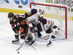 Anaheim Ducks' Adam Henrique, left, and Edmonton Oilers' Kyle Brodziak fight for the puck in front of Oilers goaltender Cam Talbot during the third period of an NHL hockey game Sunday, Jan. 6, 2019, in Anaheim, Calif. The Oilers won 4-0.