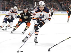 Edmonton Oilers' Jesse Puljujarvi, of Sweden, moves the puck as he is followed by Anaheim Ducks' Ondrej Kase during the first period of an NHL hockey game Sunday, Jan. 6, 2019, in Anaheim, Calif.