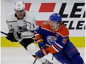 Edmonton Oilers captain Connor McDavid (right) is checked by Los Angeles Kings captain Anze Kopitar (left) during NHL hockey game action in Edmonton on November 29, 2018.