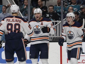 Edmonton Oilers left wing Milan Lucic, center, is congratulated by right wing Jesse Puljujarvi (98), and center Ryan Nugent-Hopkins (93) after scoring a goal against the San Jose Sharks during the second period of an NHL hockey game in San Jose, Calif., Tuesday, Jan. 8, 2019.