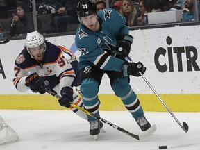 Edmonton Oilers center Connor McDavid, left, reaches for the puck next to San Jose Sharks right wing Joonas Donskoi (27), from Finland, during the second period of an NHL hockey game in San Jose, Calif., Tuesday, Jan. 8, 2019.