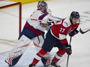 Edmonton Oil Kings goaltender Todd Scott (35) pushes Lethbridge Hurricanes Logan Barlage (27) during first period WHL action on Sunday, Jan. 13, 2019  in Edmonton.